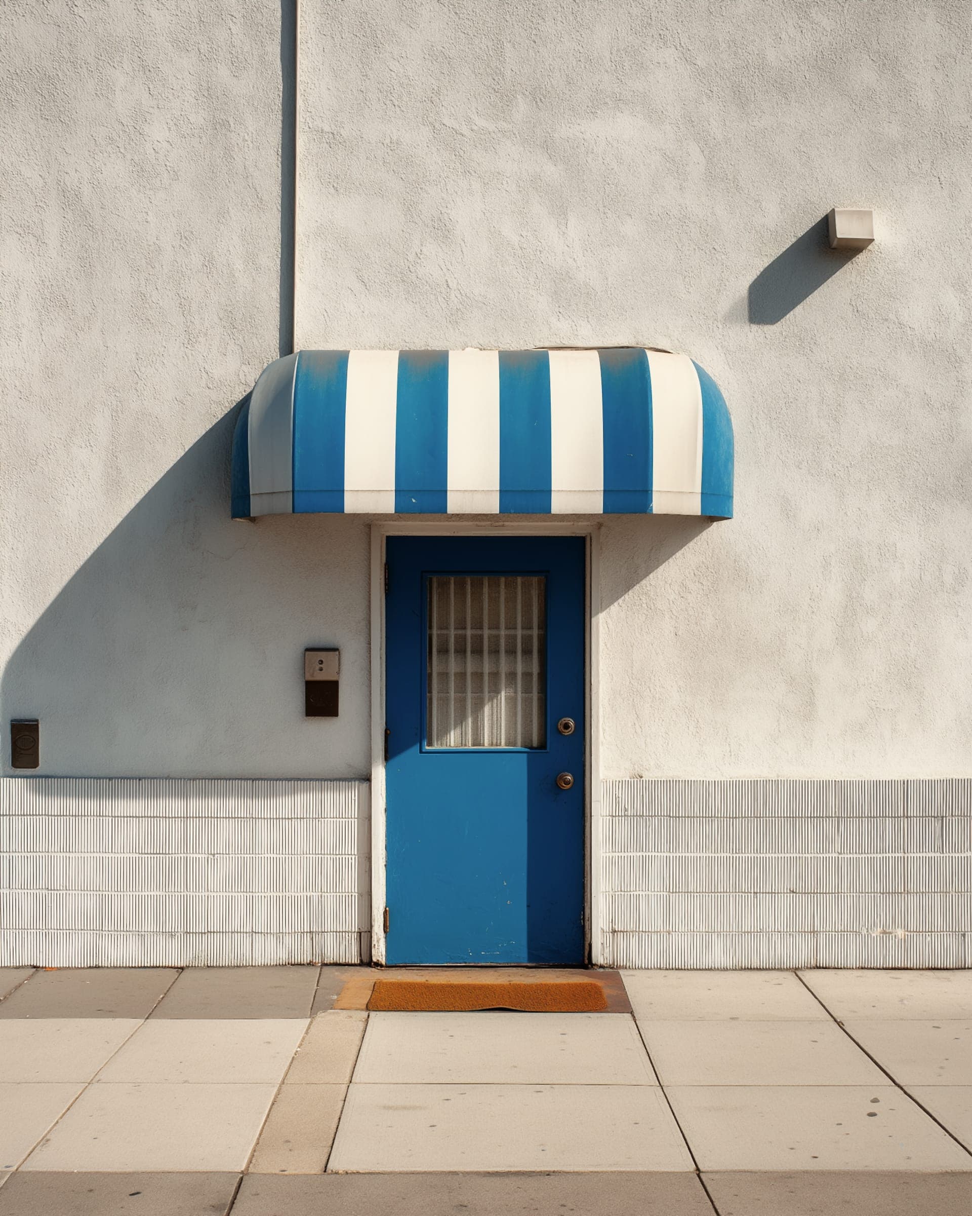 A blue front door in a white wall